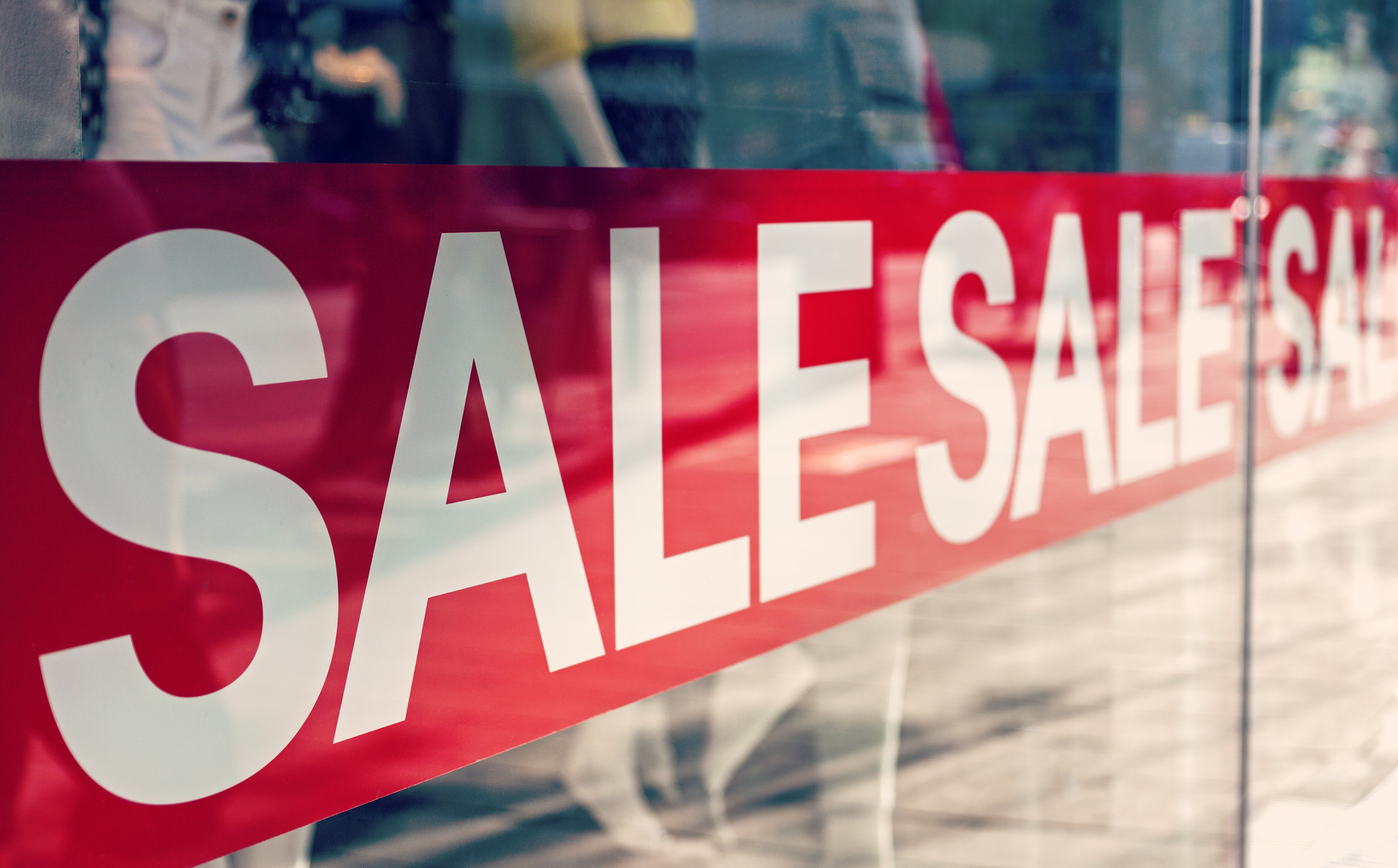 A close up of red window cling film with the word "SALE" repeated